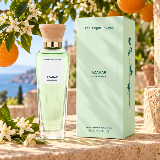 Frasco y caja de Agua Fresca de Azahar 120 ml junto a flores de azahar y naranjas en una terraza mediterránea